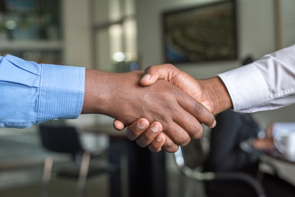Two people shaking hands to close a deal